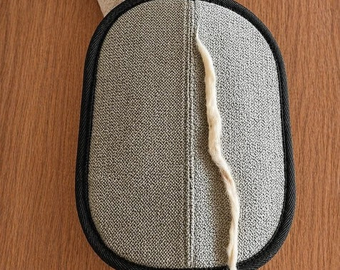 Collected pet hair gathered in a single line on the glove’s grey fabric
